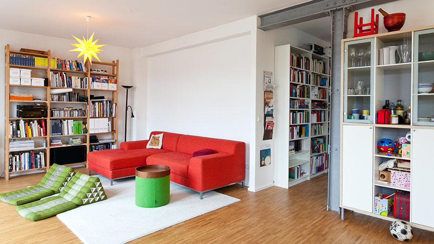 Wohnzimmer einer Familie mit Bücherwand, Couch und Spielsachen Wohnzimmer einer Familie mit Bücherwand, Couch und Spielsachen
